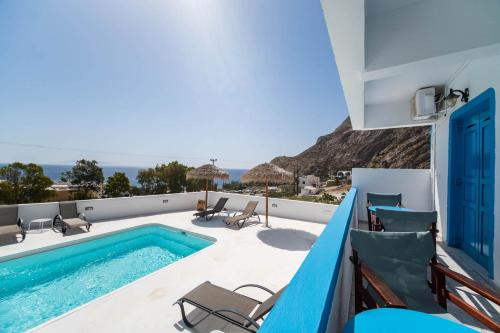 a villa with a swimming pool and a balcony at Ancient Thera Apartments in Kamari