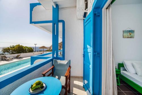 a room with a balcony with a table and a pool at Ancient Thera Apartments in Kamari