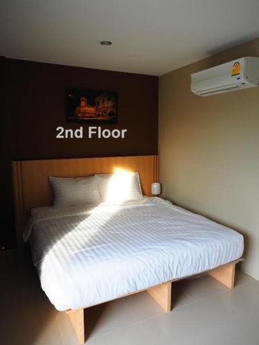 a bed in a room with a zend floor sign on the wall at Sleepwell@naiyang in Nai Yang Beach