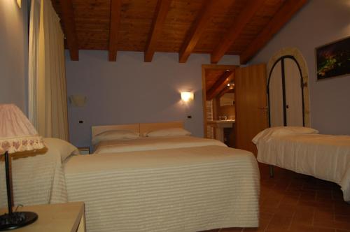 a bedroom with two beds and a mirror at Country House Il Papavero in Bagnoli Irpino