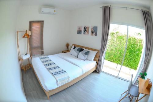 a bedroom with a large bed and a large window at Banrao Pool Villa Khaoyai บ้านเราพูลวิลล่าเขาใหญ่ in Ban Tha Maprang