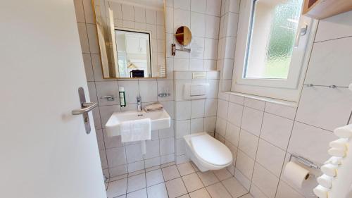 a white bathroom with a sink and a toilet at Reka-Feriendorf Montfaucon in Montfaucon