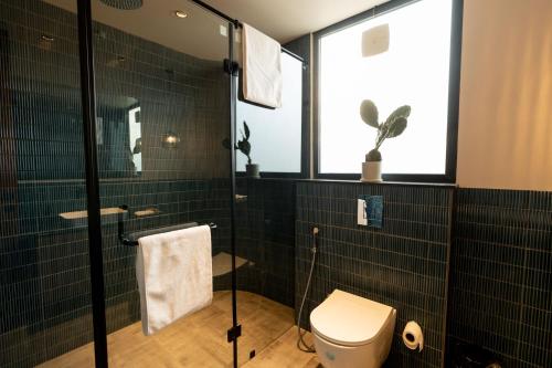 a bathroom with a toilet and a glass shower at Teela- The Glamping Resort, Jaipur in Udāsar