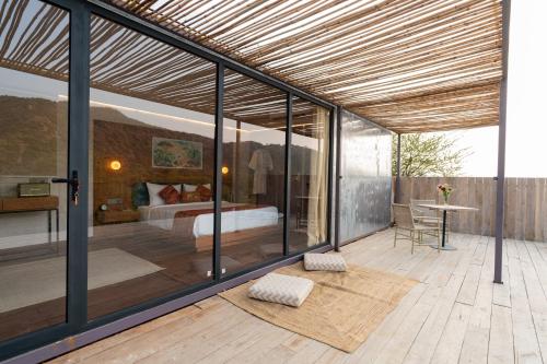 a room with a bedroom and a bed with glass walls at Teela- The Glamping Resort, Jaipur in Udāsar