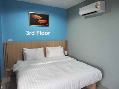 a bed in a room with a blue wall at Sleepwell@naiyang in Nai Yang Beach