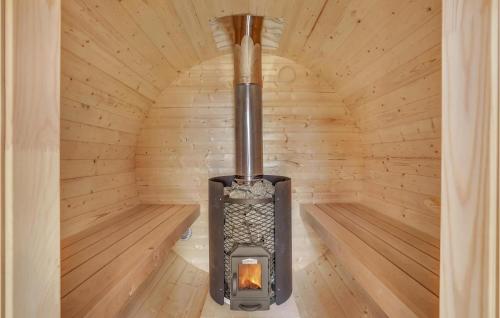 a wood burning stove in a wooden cabin at Amazing Home In Fårevejle With Sauna in Fårevejle