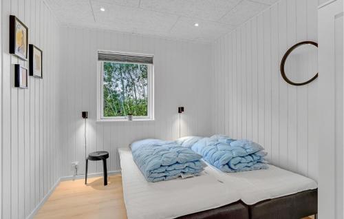 a white bedroom with a bed with blue pillows at Amazing Home In Fårevejle With Sauna in Fårevejle