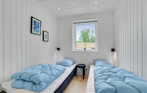 two beds in a room with blue pillows at Amazing Home In Fårevejle With Sauna in Fårevejle