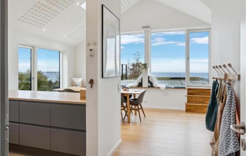 a kitchen and dining room with a view of the ocean at Cozy Home In Nykøbing Sj With Kitchen in Bøsserup