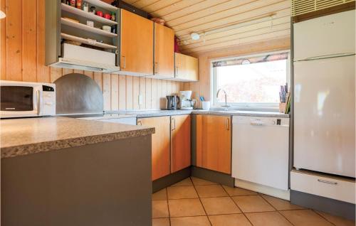 a kitchen with a white refrigerator and a sink at Holiday Home Strandvænget Slagelse in Strandlyst
