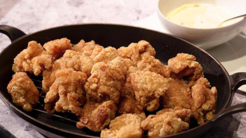 a pan filled with fried food next to a bowl of dipping sauce at Nishitetsu Grand Hotel in Fukuoka