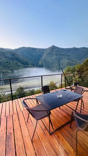 a wooden deck with a table and chairs on it at Aleksandria house in Chinkadzeebi