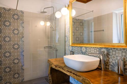 a bathroom with a sink and a mirror and a shower at Nissaki Olive Press Villas in Nisakion
