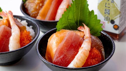 three bowls of food with fish and vegetables in them at Nishitetsu Grand Hotel in Fukuoka