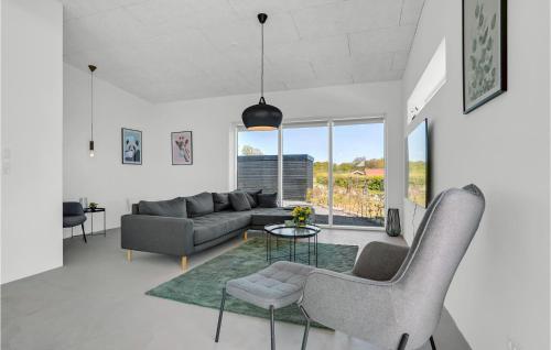a living room with a couch and a table and chairs at 3 Bedroom Nice Home In Sjølund in Sjølund