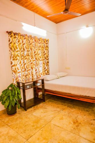 a room with a bed and a table at Marari Eden Castle in Vayalār