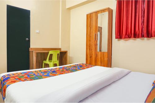 a bedroom with a bed and a wooden door at FabHotel New Falcon Inn - Nr Balewadi stadium in Pune