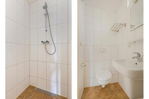 Un baño con ducha, inodoro y lavabo. en Duinstraat 10, en Domburg