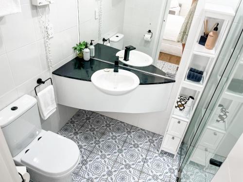 a white bathroom with a sink and a toilet at Coastal Calm Studio - A Private Studio with a Personal Touch in Marcoola