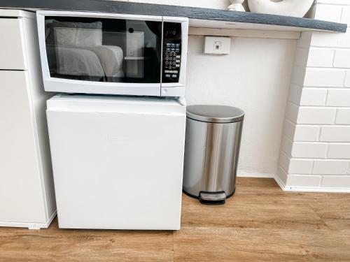 a microwave on top of a refrigerator with a trash can at Coastal Calm Studio - A Private Studio with a Personal Touch in Marcoola