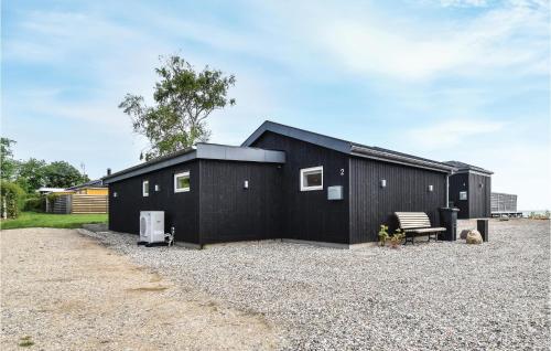 a black building with a bench in front of it at Lille Røn in Nyborg