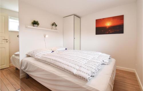 a bed with a white blanket on it in a room at Lille Røn in Nyborg