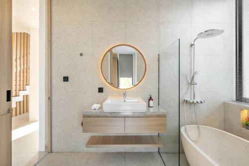 ein Badezimmer mit Waschbecken, Badewanne und Spiegel in der Unterkunft Private Villa Ayra 9B by OriVista 10mins to Melasti Beach in Uluwatu