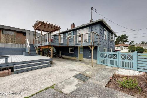 a large blue house with a porch and a deck at 3 Bedroom Beach Oasis - HOT TUB - Pet Friendly in Seaside