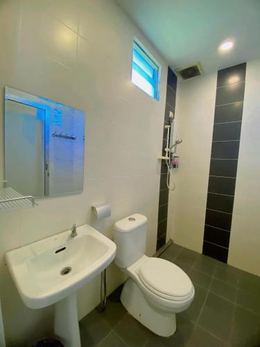 a bathroom with a white toilet and a sink at Ziella De Villa in Pantai Cenang