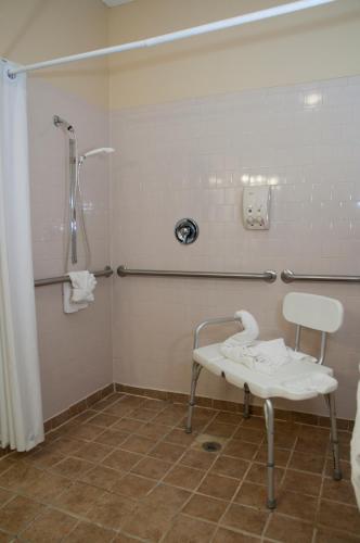 a bathroom with a shower and a white table at The Stone Castle Hotel & Conference Center in Branson