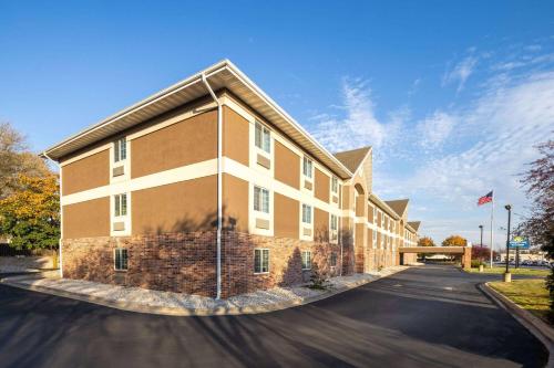 a large brick building with a blue sky at Days Inn & Suites by Wyndham Green Bay WI in Green Bay