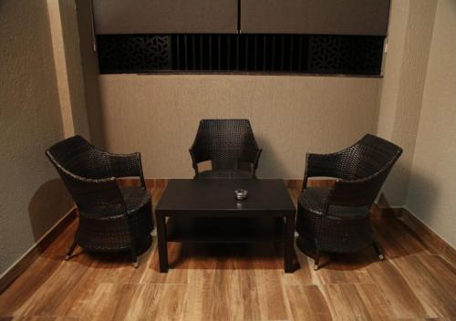 a room with chairs and a table and a table at Dakshin Suites in Srīkākulam