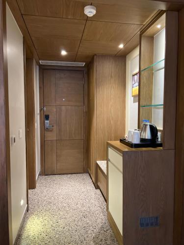 a hallway with a door and a kitchen with a counter at Hotel Apricia in Ludhiana