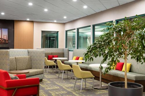 a waiting room with chairs and tables and a tree at Hampton Inn Richland-Tri Cities in Richland