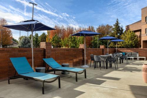 a patio with blue chairs and tables and umbrellas at Hampton Inn Richland-Tri Cities in Richland