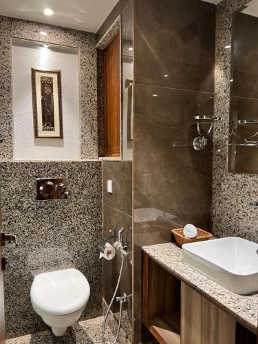 a bathroom with a toilet and a sink and a shower at Hotel Apricia in Ludhiana