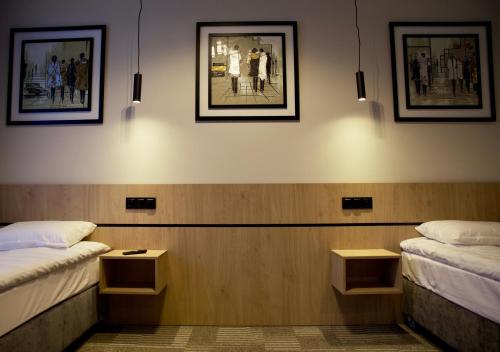two beds in a room with pictures on the wall at Sarmata in Czyżówek