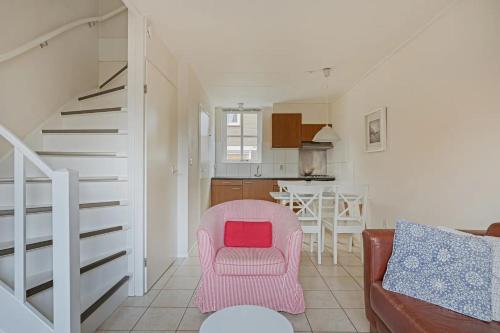 sala de estar con silla rosa y cocina en Duinstraat 10, en Domburg