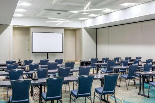 a conference room with tables and chairs and a white screen at DoubleTree by Hilton Boston/Westborough in Westborough