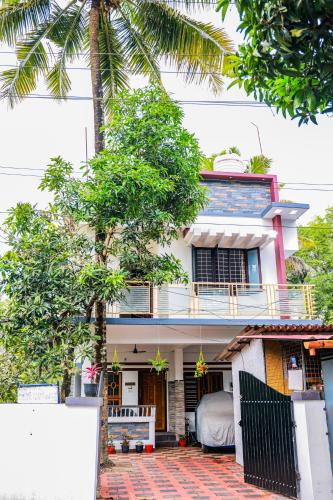 a house with a bed on the balcony of it at Marari Eden Castle in Vayalār