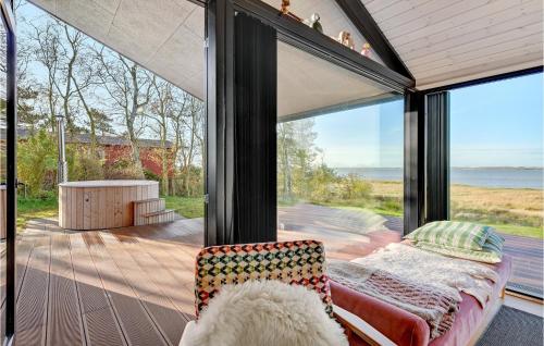 a glass house with a couch and a view of the ocean at Cozy Home In Højslev With Wifi in Højslev