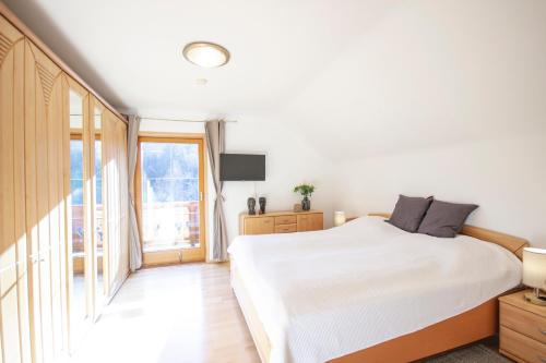 a bedroom with a white bed and a large window at Ferienhaus Eggarter in Rennweg