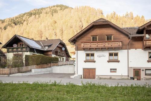a group of wooden buildings with mountains in the background at Ferienhaus Eggarter in Rennweg