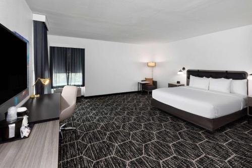 a hotel room with a bed and a flat screen tv at La Quinta Inn & Suites by Wyndham Austin Parmer Tech Ridge in Austin