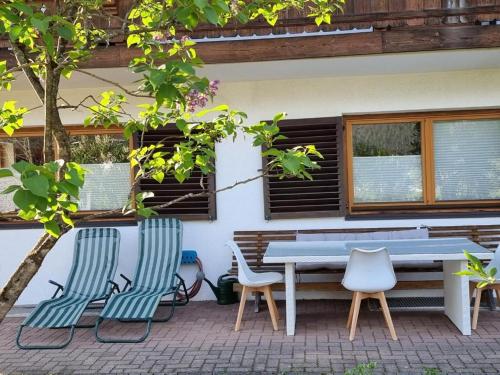 a picnic table and chairs in front of a house at 80 m2, für bis 6 Personen mit tollem Skigebiet, zentral und doch ruhig in Waidring