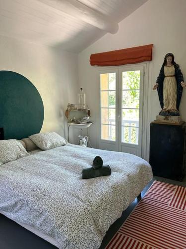 - une chambre avec un lit doté d'une statue dans l'établissement Mas de la source, à Le Beaucet