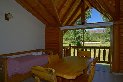 a bedroom with a table and a bed and a window at Cabañas Posada del Angel in Valle Grande