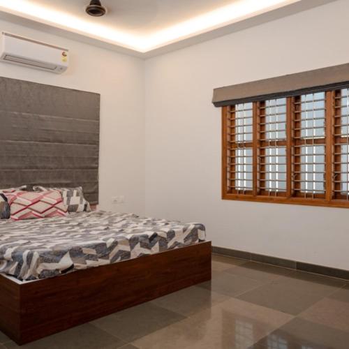 a bedroom with a bed in a room with a window at Anuradha Homestay in Mangalore