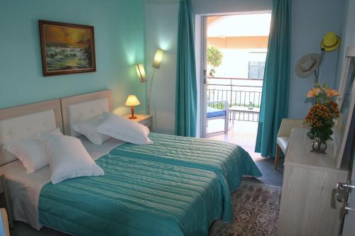 a bedroom with a bed with a green comforter at Roda Pearl Resort in Roda