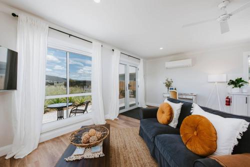 a living room with a couch and a large window at Joseph's Place - A Restful Retreat for Two in Mudgee
